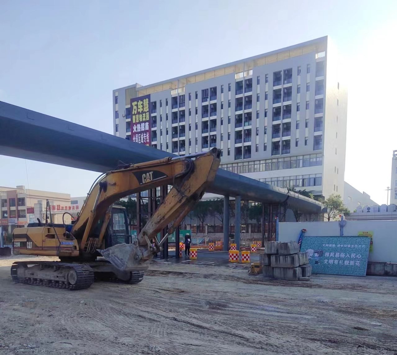 Crane lifting a fabricated steel footbridge span into position above a road