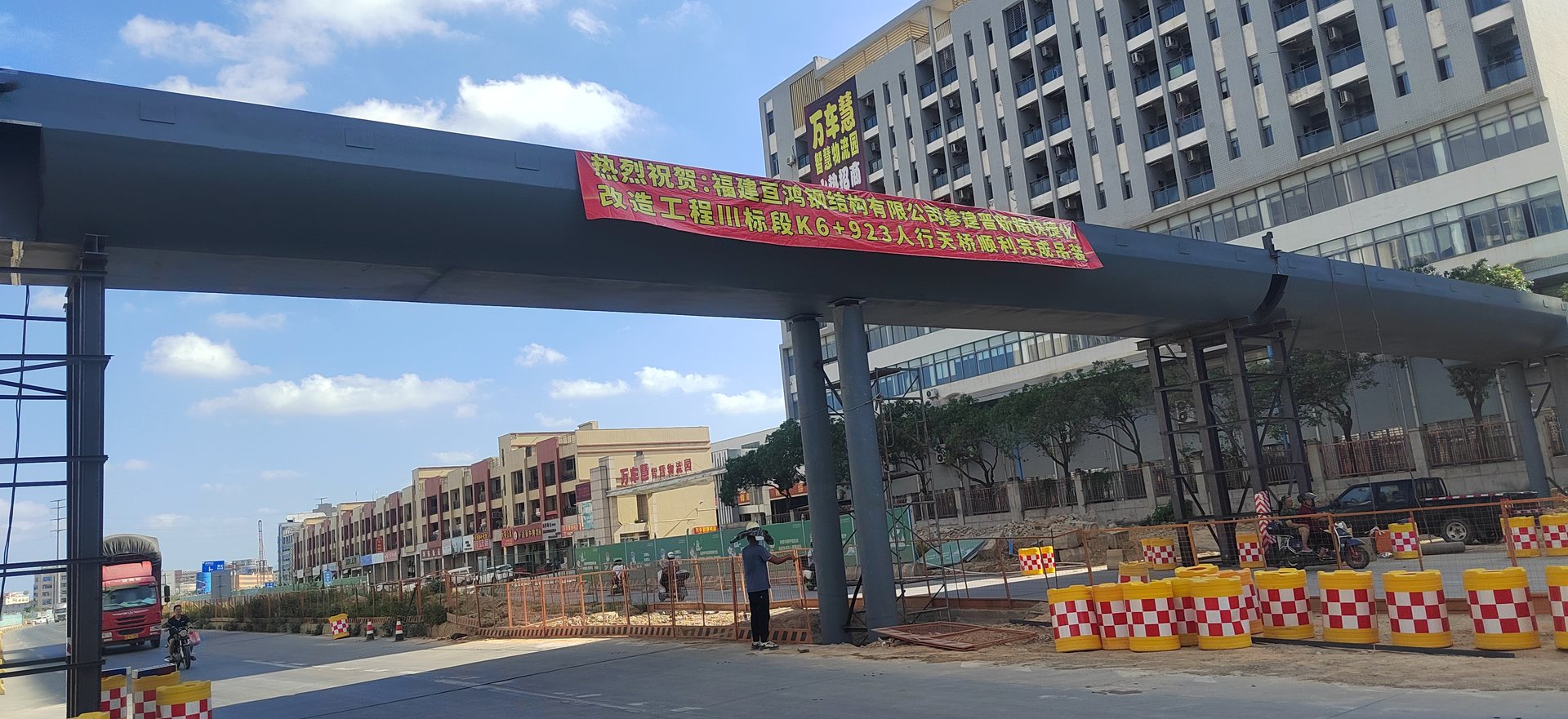 Completed steel footbridge crossing a city road