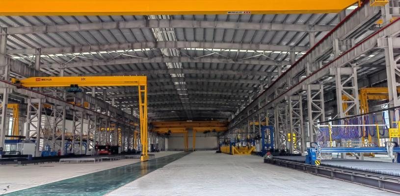 Wide interior view of the Genhong steel fabrication workshop with overhead cranes