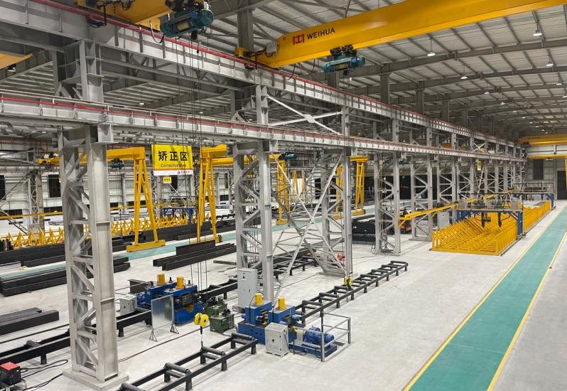Full length of the fabrication hall with gantry cranes and staged steelwork