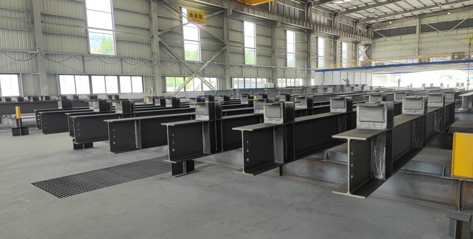 Long view of the workshop with fabricated steel frames staged for finishing